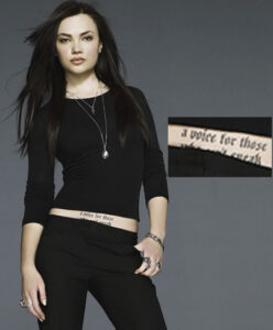 Elina Ivanova displaying her lower stomach tattoo that reads 'a voice for those who can't speak