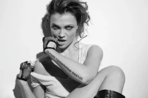 Elina Ivanova showing her Cyrillic forearm tattoo in a black and white photoshoot