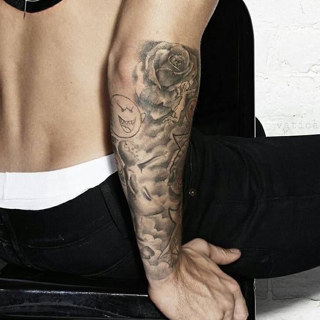 “Close-up of Justin Bieber’s arm sleeve tattoos with roses and shading.”