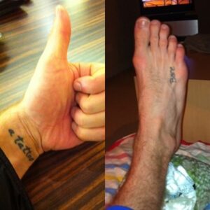 Harry Judd displaying his wrist tattoo “a tattoo” and foot tattoo “Boo”