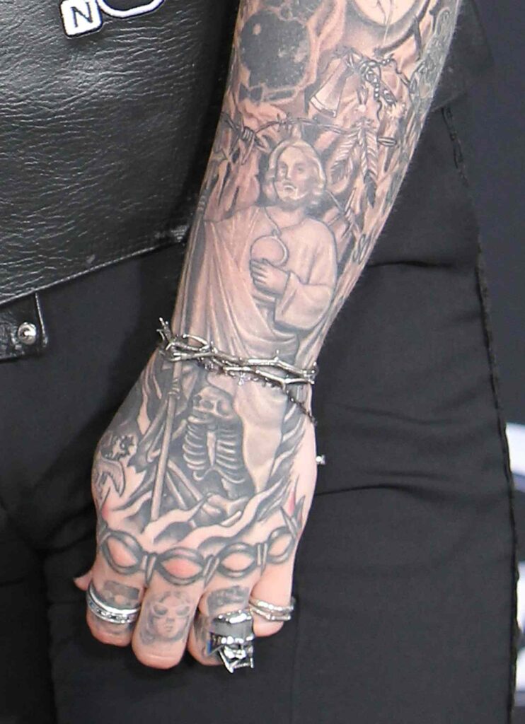 “Post Malone’s arm tattoo featuring religious imagery including a Jesus portrait and detailed shading.”